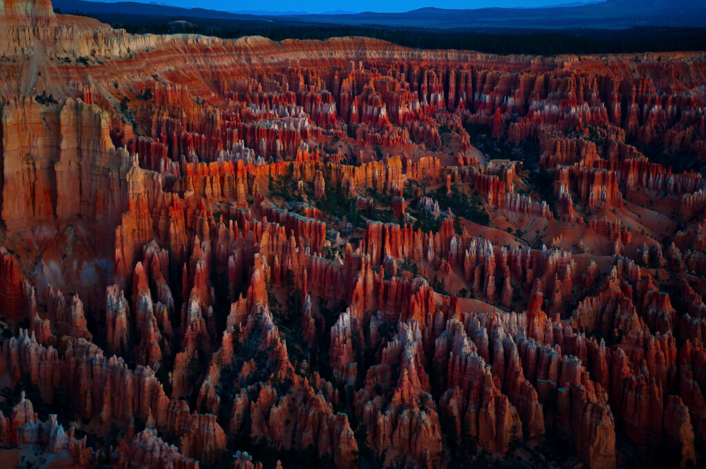 Bryce Canyon National Park's hoodoo rock formations in Utah during blue hour, with layered orange sandstone spires