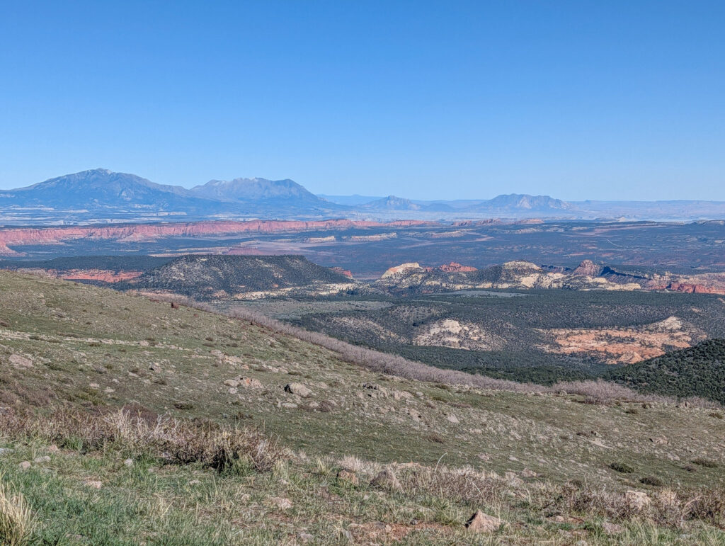 Panoramic view north from Boulder Mountain's grassy Aquarius Plateau toward the distant Henry Mountains at golden hour.