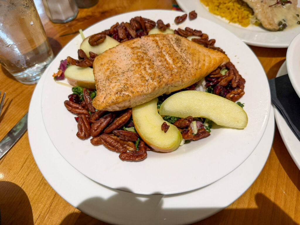 A grilled salmon fillet served over a kale salad with candied pecans and crisp apple slices at the Red Rock Grill in Zion Lodge.