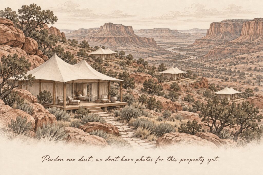 Large canvas glamping tents with wood decks overlooking a scenic red rock valley